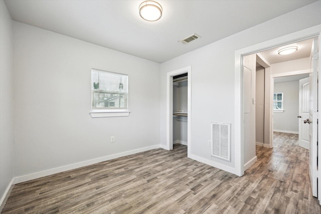 unfurnished bedroom with hardwood / wood-style flooring and a closet