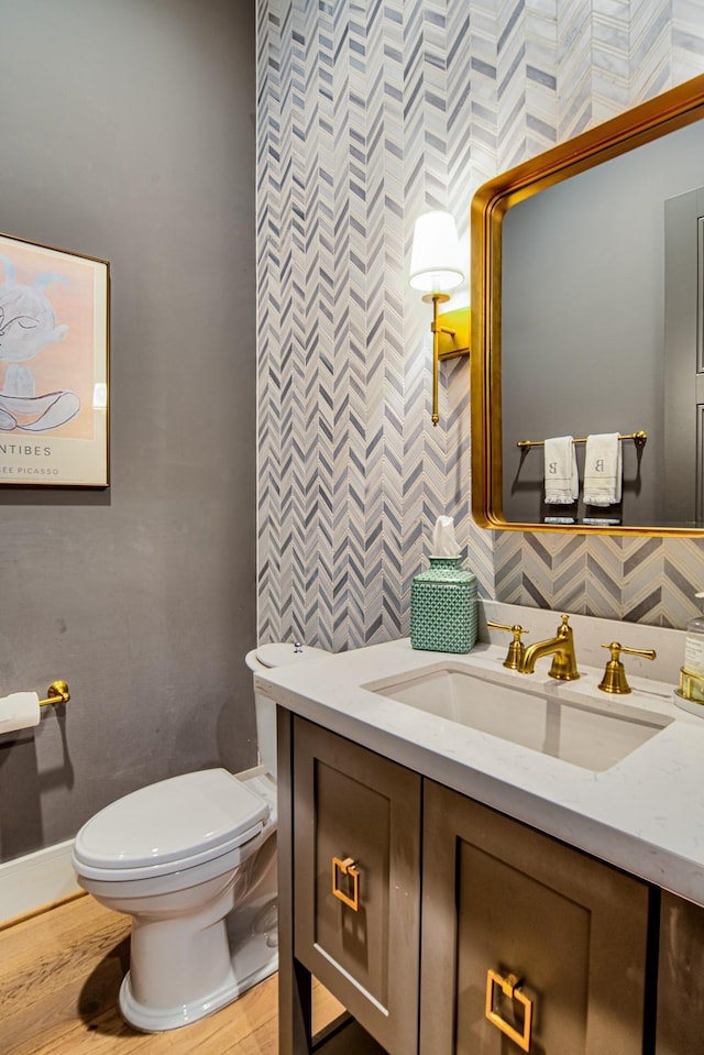 bathroom featuring baseboards, decorative backsplash, toilet, vanity, and tile walls