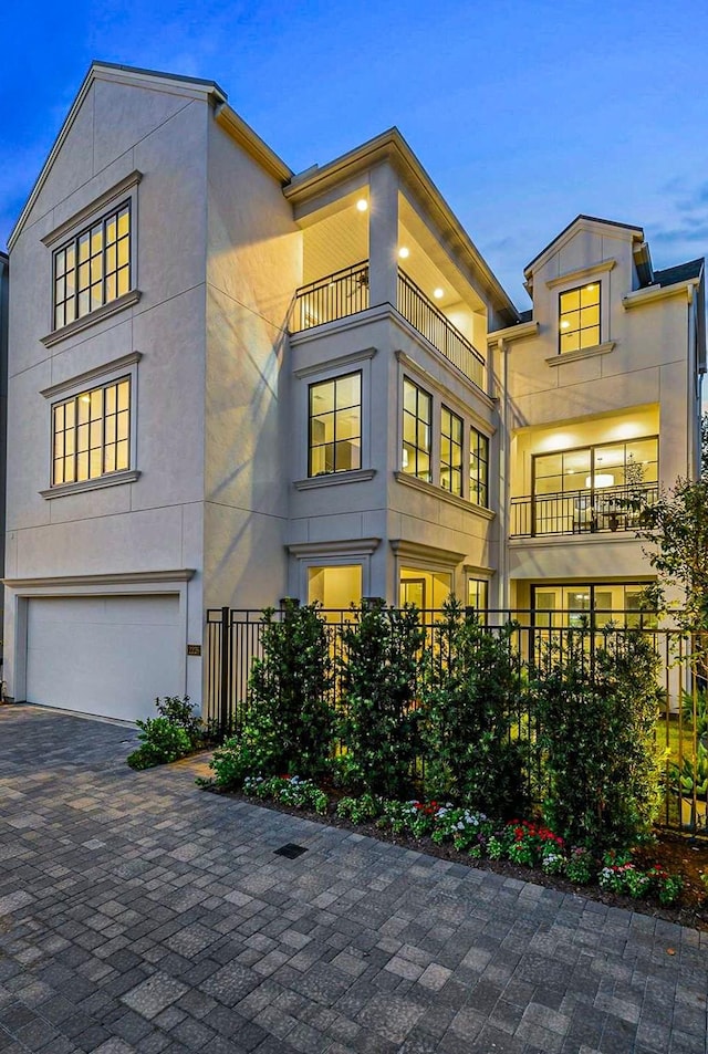 view of front facade with a garage, decorative driveway, and stucco siding