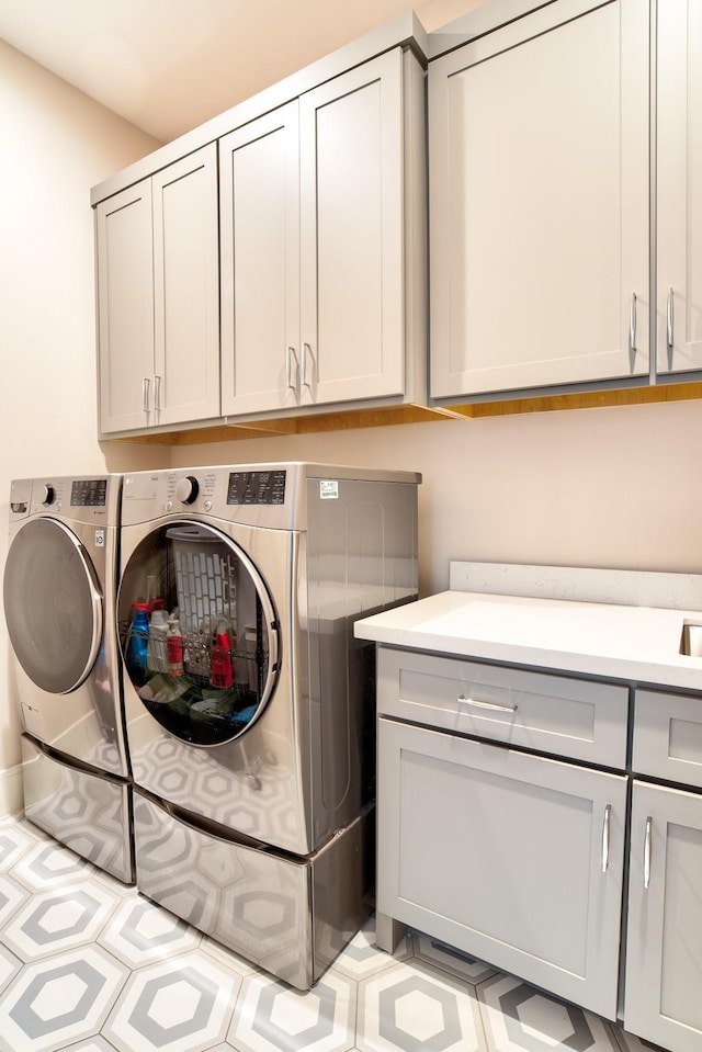 laundry room featuring washing machine and dryer and cabinet space