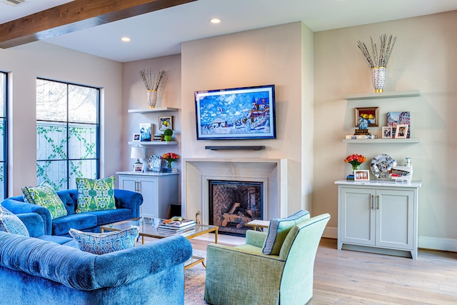 living area featuring visible vents, beamed ceiling, light wood-type flooring, a fireplace, and recessed lighting