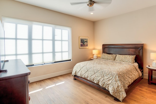 bedroom with baseboards, ceiling fan, and light wood finished floors