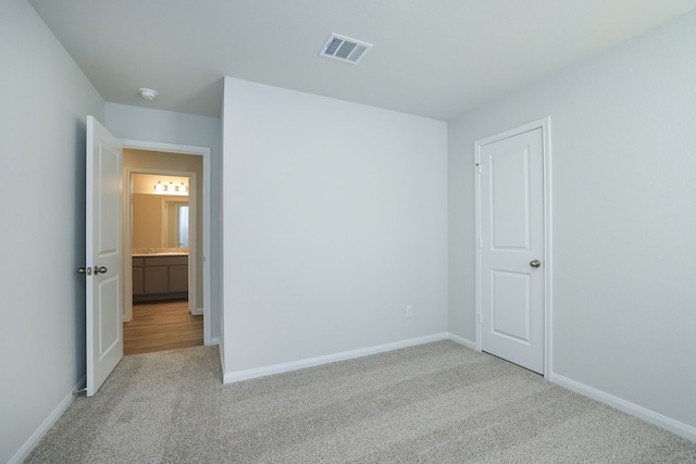 unfurnished bedroom featuring light carpet, visible vents, and baseboards