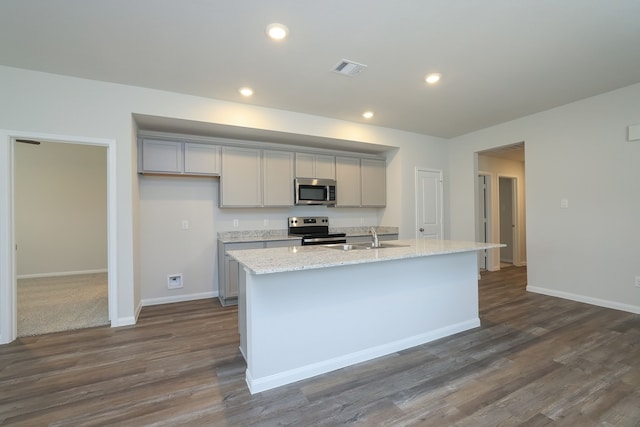 kitchen with recessed lighting, a center island with sink, gray cabinets, and appliances with stainless steel finishes
