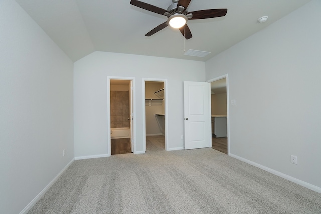 unfurnished bedroom with baseboards, carpet floors, a closet, and a spacious closet