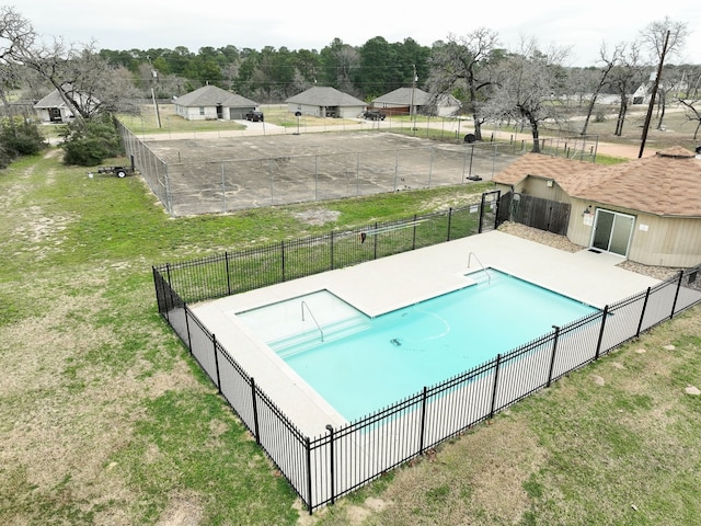 community pool featuring a yard and fence