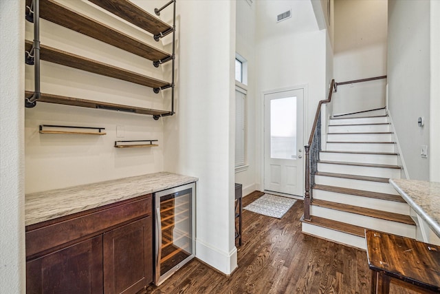 foyer with dark wood-type flooring, bar, and beverage cooler