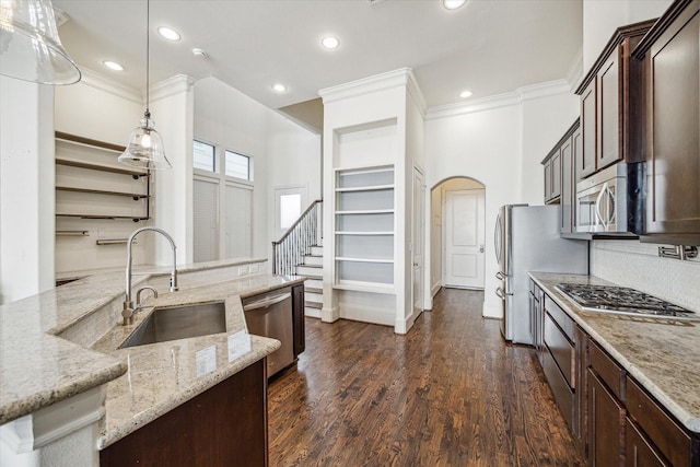 kitchen with sink, decorative light fixtures, dark hardwood / wood-style flooring, stainless steel appliances, and light stone countertops