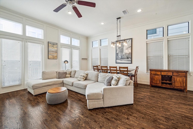 living room with dark hardwood / wood-style flooring, crown molding, and ceiling fan