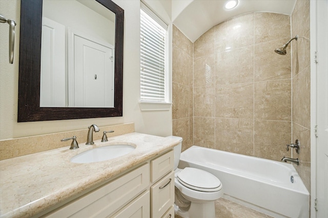 full bathroom featuring tiled shower / bath, vanity, and toilet