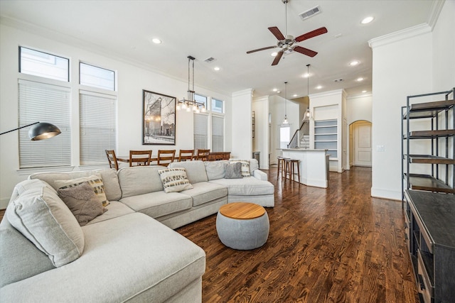 living room featuring crown molding, ceiling fan with notable chandelier, and dark hardwood / wood-style floors