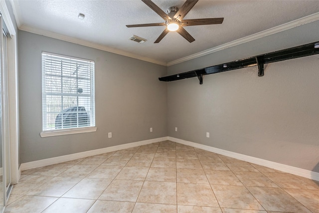 spare room with ceiling fan, ornamental molding, a textured ceiling, and light tile patterned flooring