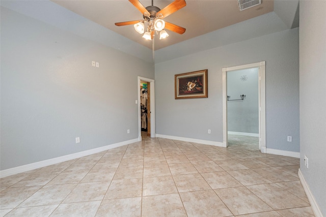 spare room with ceiling fan and light tile patterned floors