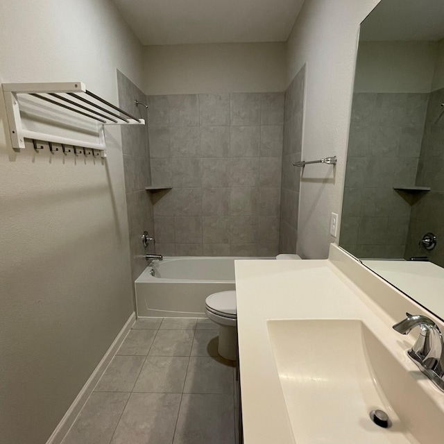 bathroom with bathtub / shower combination, toilet, a sink, baseboards, and tile patterned floors