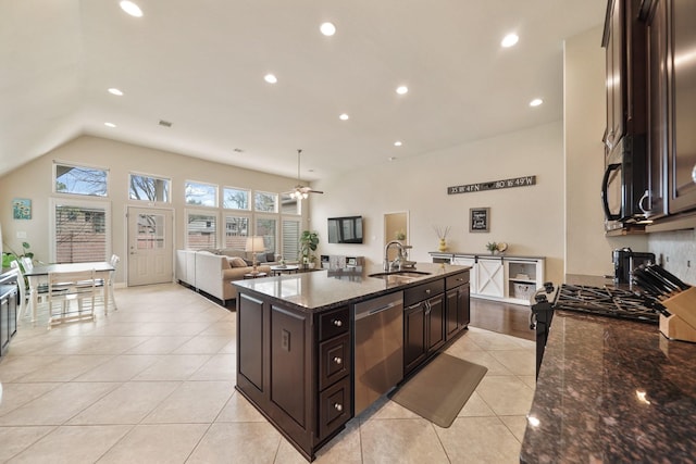 kitchen featuring dark brown cabinetry, sink, dark stone countertops, dishwasher, and an island with sink