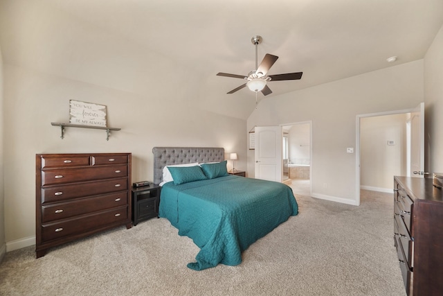 bedroom with ceiling fan, light colored carpet, vaulted ceiling, and ensuite bath