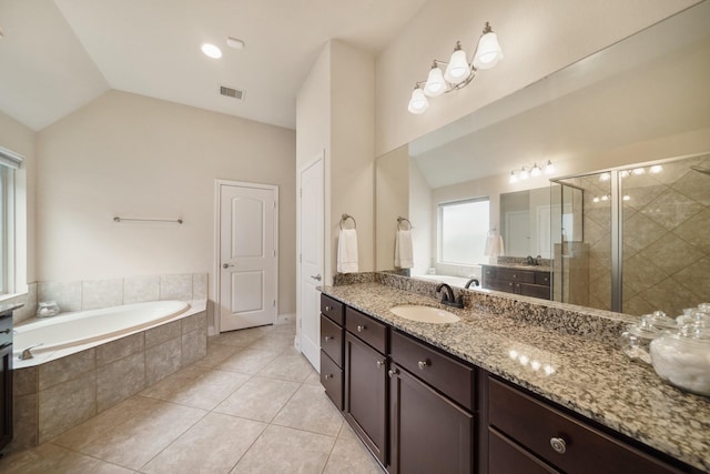 bathroom featuring tile patterned flooring, vaulted ceiling, independent shower and bath, and vanity