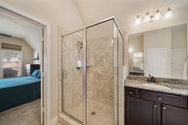 bathroom featuring vanity, a shower with shower door, and vaulted ceiling