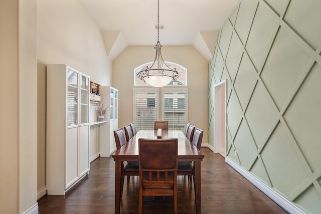 dining room with dark hardwood / wood-style floors, a chandelier, and high vaulted ceiling