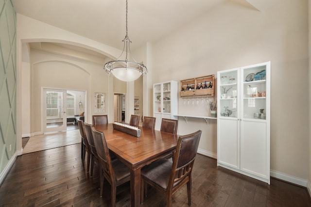 dining room featuring dark hardwood / wood-style flooring and a high ceiling