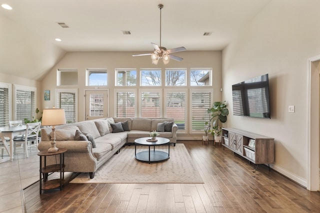 living room with a high ceiling, dark hardwood / wood-style floors, and ceiling fan