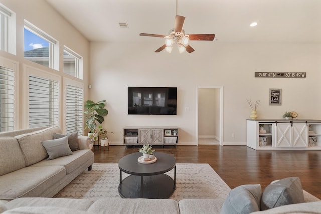 living room featuring dark wood-type flooring and ceiling fan