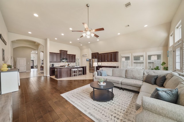 living room featuring sink, dark wood-type flooring, high vaulted ceiling, and ceiling fan