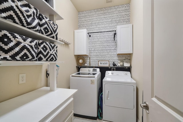 laundry area featuring washing machine and dryer and cabinets