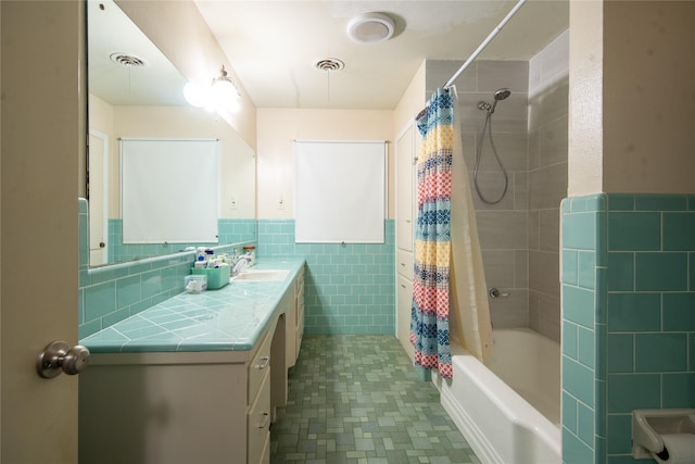 bathroom with vanity, tile walls, and shower / bath combo with shower curtain