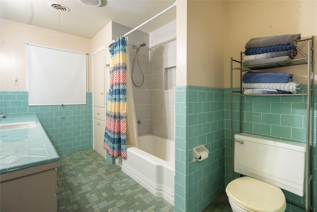 full bathroom with tile walls, tile patterned flooring, vanity, toilet, and shower / bath combo