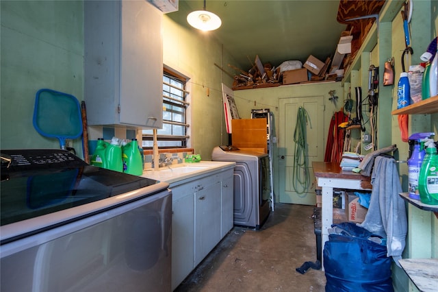 laundry area with cabinets, washing machine and dryer, and sink