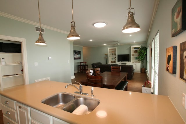 kitchen featuring sink, ceiling fan, ornamental molding, dark hardwood / wood-style flooring, and decorative light fixtures