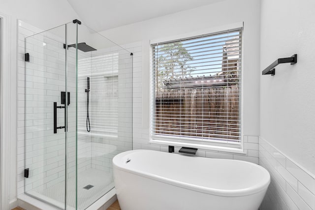 bathroom with tile walls and independent shower and bath