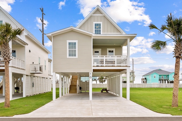 beach home with covered porch, stairway, board and batten siding, a carport, and a front lawn