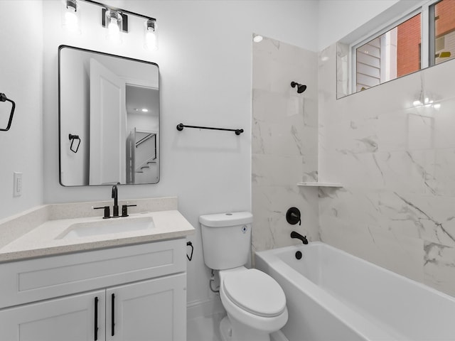 full bathroom featuring tiled shower / bath, vanity, and toilet