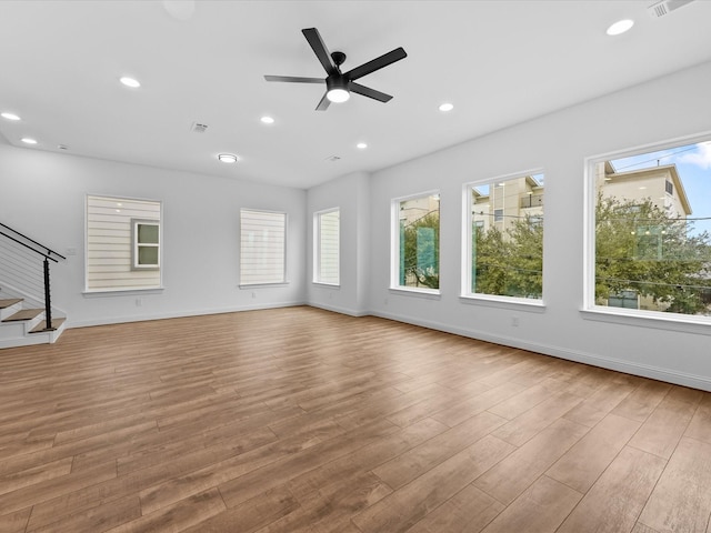 unfurnished living room featuring ceiling fan, a healthy amount of sunlight, and light hardwood / wood-style floors