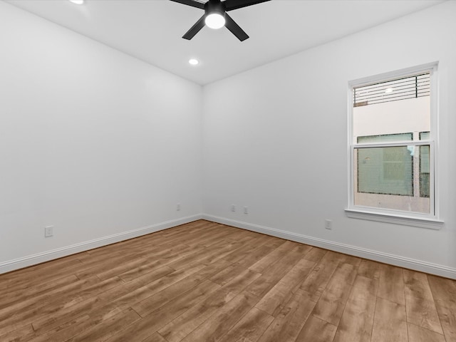 empty room featuring hardwood / wood-style flooring, a wealth of natural light, and ceiling fan