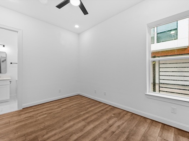 empty room with ceiling fan and light hardwood / wood-style floors