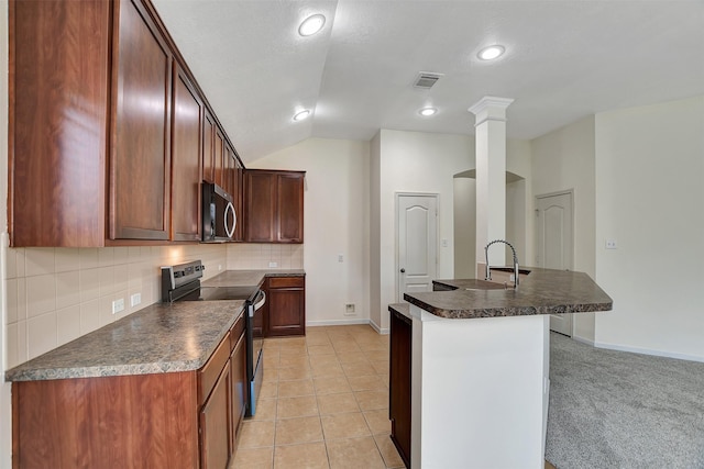 kitchen featuring lofted ceiling, sink, appliances with stainless steel finishes, a kitchen island with sink, and decorative backsplash