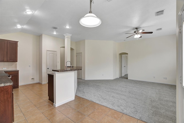 kitchen with decorative light fixtures, lofted ceiling, decorative backsplash, light colored carpet, and ceiling fan