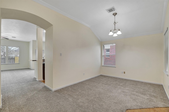 carpeted spare room featuring ornamental molding, vaulted ceiling, and a notable chandelier