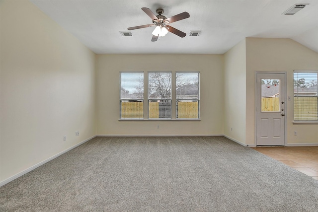 carpeted empty room featuring ceiling fan, a healthy amount of sunlight, and lofted ceiling