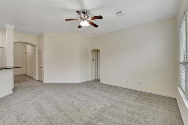 empty room featuring light carpet, a wealth of natural light, and ceiling fan