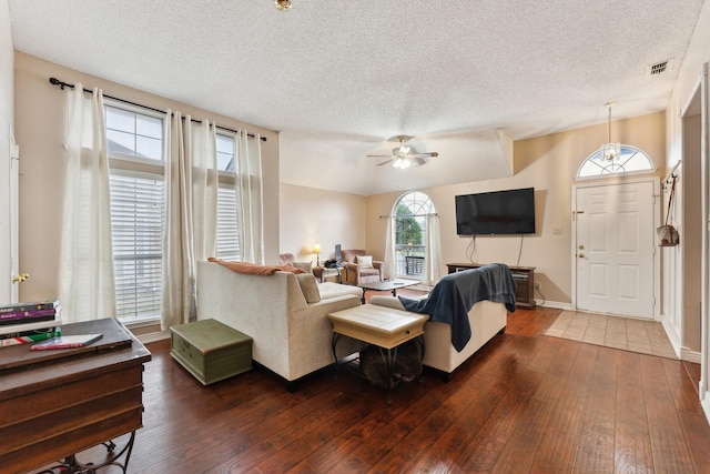 living room with ceiling fan, dark wood-type flooring, and a textured ceiling