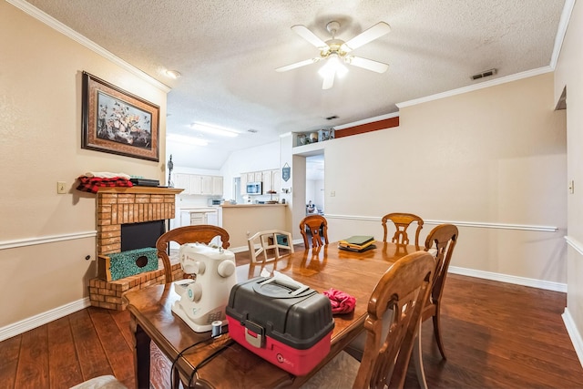 dining space with hardwood / wood-style floors, a fireplace, ornamental molding, and ceiling fan