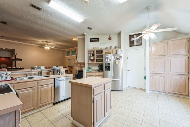 kitchen featuring sink, a textured ceiling, appliances with stainless steel finishes, a kitchen island, and ceiling fan