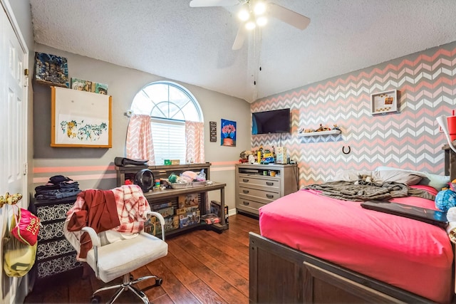 bedroom with ceiling fan, lofted ceiling, dark hardwood / wood-style floors, and a textured ceiling