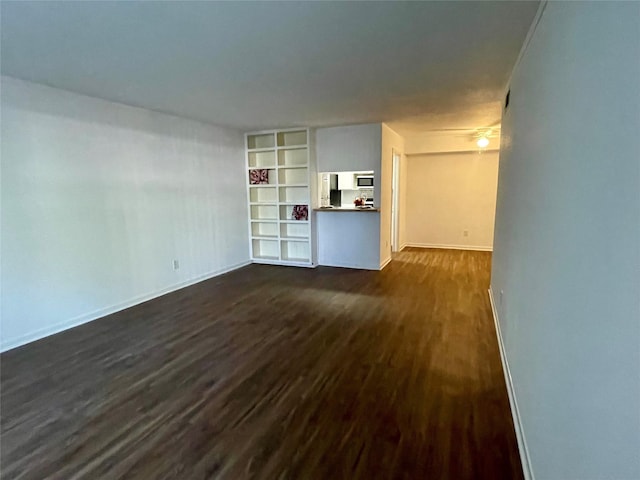 unfurnished living room with built in shelves and dark hardwood / wood-style flooring