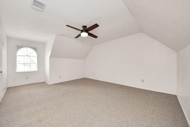 bonus room with vaulted ceiling, light colored carpet, and ceiling fan