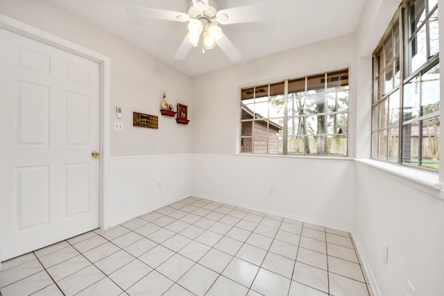 tiled spare room featuring ceiling fan